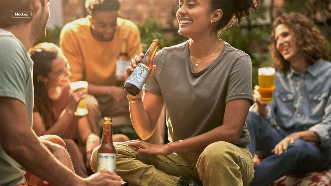 Mockup fotografico campagna comunicazione progetto cliente reale Birra Agricola Barabina per Cascina Guanella Valmadrera: momento conviviale con gruppo di amici che brindano con bottiglie di birra artigianale. Commessa professionale di riposizionamento br